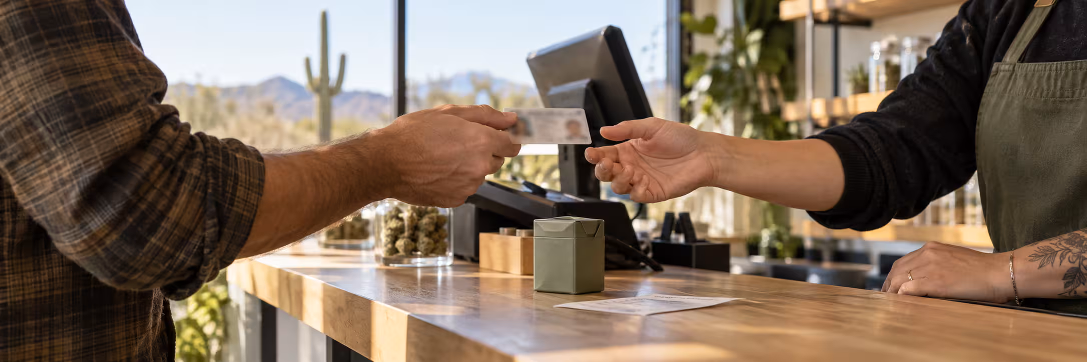 Arizona Cannabis Laws and Dispensary ID Check Customer presenting identification for age verification at a licensed cannabis dispensary in Arizona.